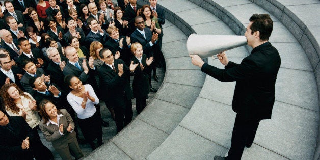 Businessman Standing on Steps Outside Talking Through a Megaphone, Large Group of Business People Listening and Applauding