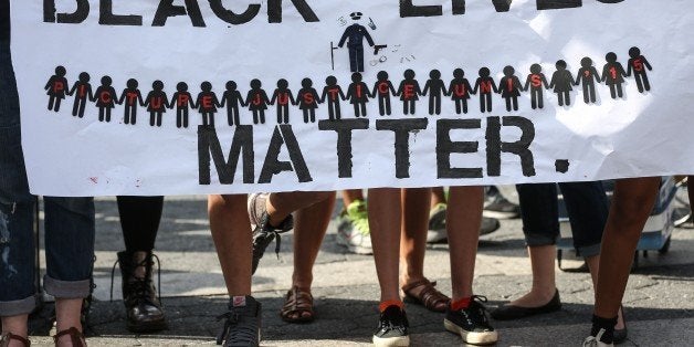 NEW YORK, NY - AUGUST 09: People hold banners reading 'Black Lives Matter' during a rally to mark the one year anniversary of the death of Michael Brown at Union Square in New York, NY on August 09, 2015. Brown was killed by police officer Darren Wilson in Ferguson, Missouri, and his death set off nationwide protest against police brutality. (Photo by Cem Ozdel/Anadolu Agency/Getty Images)