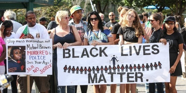 NEW YORK, NY - AUGUST 09: People hold banners reading 'Black Lives Matter' during a rally to mark the one year anniversary of the death of Michael Brown at Union Square in New York, NY on August 09, 2015. Brown was killed by police officer Darren Wilson in Ferguson, Missouri, and his death set off nationwide protest against police brutality. (Photo by Cem Ozdel/Anadolu Agency/Getty Images)