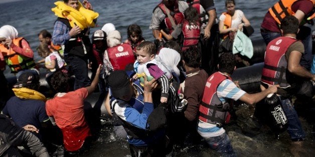 Syrian refugees arrive on the shores of the Greek island of Lesbos after crossing the Aegean Sea from Turkey on a inflatable