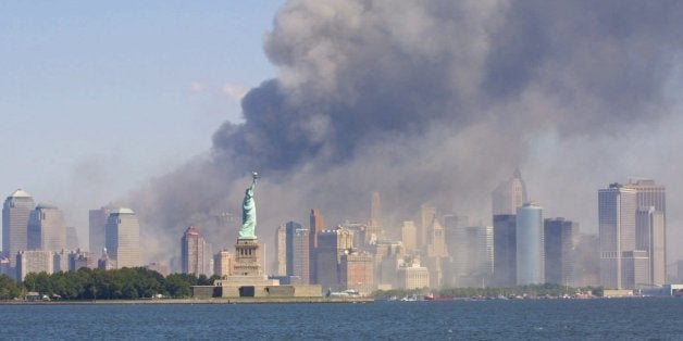 The Statue of Liberty stands as smoke billows from the World Trade Center in New York, Tuesday, Sept 11, 2001 after terrorist