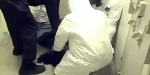 In this Feb. 3, 2015 frame from video provided by the Fairfax County, Va., Sheriff, deputies work to restrain Natasha McKenna during a cell transfer, in Fairfax, Va. The video was released Thursday, Sept. 10, two days after prosecutors said they would not bring criminal charges shows a prolonged struggle with the mentally ill inmate who died after being shocked with a stun gun. (Fairfax County Sheriff via AP)