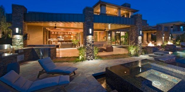 House exterior lit up at night, with patio furniture