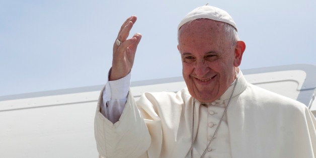 Pope Francis waves from the top of the stairs of his plane at the airport in Santiago, Cuba, Tuesday Sept. 22, 2015. Pope Francis wrapped up his visit to Cuba Tuesday by celebrating an homily at the country's most revered shrine and giving a pep talk with families before flying north to Washington for the start of his U.S. tour. (Ismael Francisco/Cubadebate Via AP)