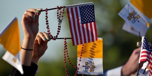 People wave US and Vatican flags as they wait for the arrival of the Pope Francis at the White House in Washington DC on Sept