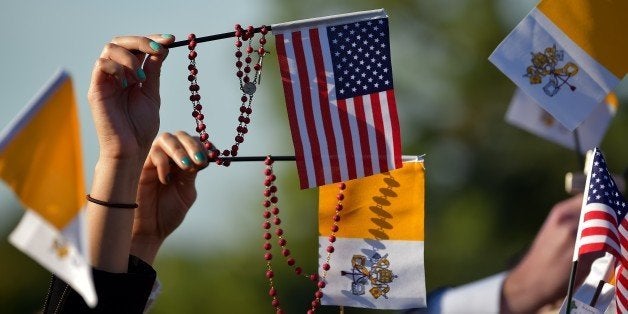 People wave US and Vatican flags as they wait for the arrival of the Pope Francis at the White House in Washington DC on September 22, 2015. A crowd of thousands are stretched back across the gloriously sun-kissed South Lawn awaiting the arrival of Pope Francis and President Barack Obama. AFP PHOTO / VINCENZO PINTO (Photo credit should read VINCENZO PINTO/AFP/Getty Images)