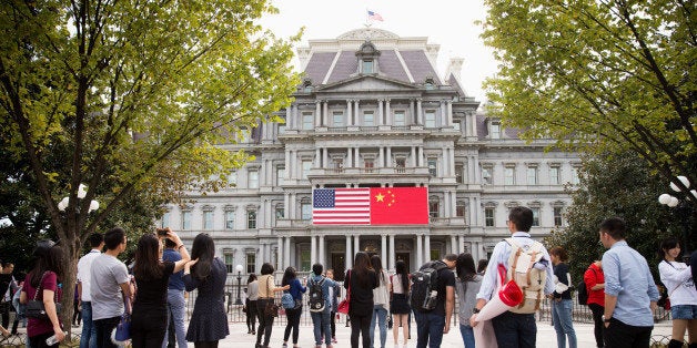 In this Thursday, Sept. 24, 2015, photo, China's flag is displayed next to the American flag on the side of the Old Executive Office Building on the White House complex in Washington, the day before a state visit by Chinese President Xi Jinping. Chinese state media characterize Xiâs first state visit to the U.S. in positive terms, reporting that Xi has reassured U.S. businesses of Chinaâs healthy economy and dispelled concerns about hacking and its ambitions in the South China Sea _ the two key issues for Washington. (AP Photo/Andrew Harnik)