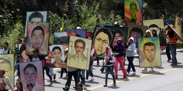 Students of the rural teacher college of Ayotzinapa hold portraits of the 43 missing students during a march from the school to Chilpancingo, Guerrero State, Mexico, on September 24, 2015. Next September 26 will mark the first anniversary of the mass disappearance. The students went missing after they were attacked by local police in the city of Iguala on September 26, 2014. Only one student was positively identified among charred remains while the attorney general said last week that there was a possible DNA match for a second one. AFP PHOTO / PEDRO PARDO (Photo credit should read Pedro PARDO/AFP/Getty Images)