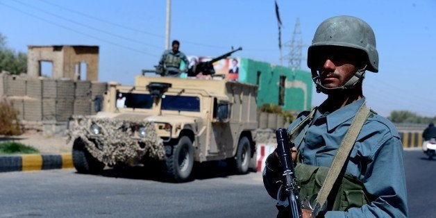 Afghan policemen keep watch at a checkpoint in Herat on September 30, 2015. AFP PHOTO / Aref Karimi (Photo credit