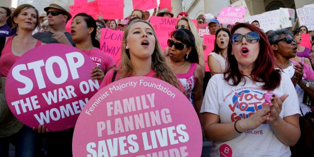 Planned Parenthood supporters rally for women's access to reproductive health care on ``National Pink Out Day'' at Los Angeles City Hall, Tuesday, Sept. 29, 2015. (AP Photo/Nick Ut)