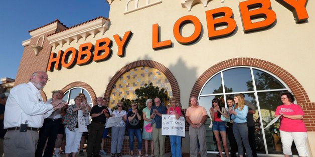 CLARIFIES THAT REV. PRESCOTT WAS HOLDING A VIGIL IN OPPOSITION TO THE SUPREME COURT RULING - Rev. Bruce Prescott, left, leads a vigil outside a Hobby Lobby store in Edmond, Okla., Monday, June 30, 2014, in opposition to the Supreme Court's decision that some companies like the Oklahoma-based Hobby Lobby chain of arts-and-craft stores can avoid the contraceptives requirement in President Barack Obama's health care overhaul, if they have religious objections. (AP Photo/Sue Ogrocki)