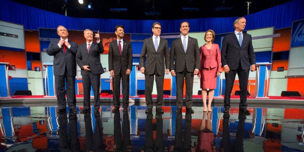 Republican presidential candidates from left, Jim Gilmore, Lindsey Graham, Bobby Jindal, Rick Perry, Rick Santorum, Carly Fiorina, and George Pataki take the stage for a pre-debate forum at the Quicken Loans Arena, Thursday, Aug. 6, 2015, in Cleveland. Seven of the candidates have not qualified for the primetime debate. (AP Photo/Andrew Harnik)