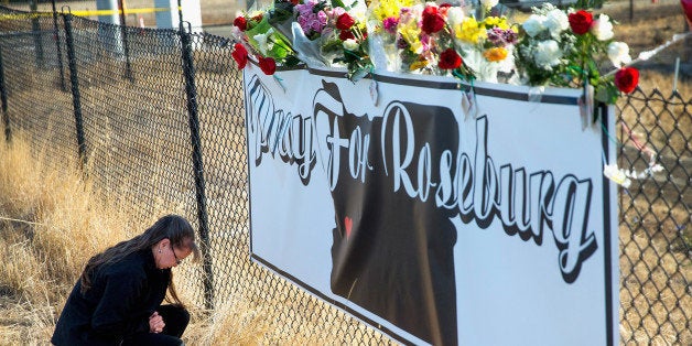 ROSEBURG, OR - OCTOBER 03: Robin Griffiths leaves flowers at a memorial along the road to Umpqua Community College on October 3, 2015 in Roseburg, Oregon. On Thursday 26-year-old Chris Harper Mercer went on a shooting rampage on the campus killing nine people and wounding nine others before killing himself. (Photo by Scott Olson/Getty Images)