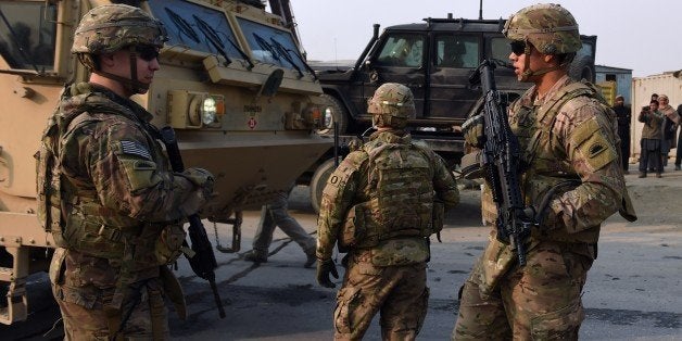 US soldiers stands guards at the scene of a suicide car bomb attack on a European Union police vehicle along the Kabul-Jalalabad road in Kabul on January 5, 2015. A suicide car bomb hit a European Union police vehicle in Kabul on January 5, killing at least one passer-by but not injuring any of the passengers, officials said, days after the NATO combat mission ended in Afghanistan. AFP PHOTO/Wakil KOHSAR (Photo credit should read WAKIL KOHSAR/AFP/Getty Images)