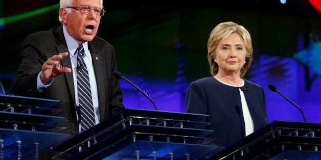 Hillary Rodham Clinton, right, looks on as Sen. Bernie Sanders, of Vermont, speaks during the CNN Democratic presidential deb