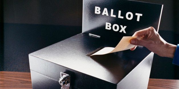 Man Inserting Voting Paper into a Ballot Box