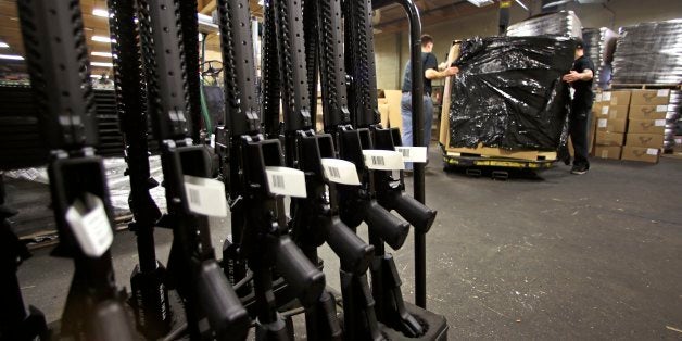 A rack of AR-15 rifles stand to be individually packaged as workers move a pallet of rifles for shipment at the Stag Arms com
