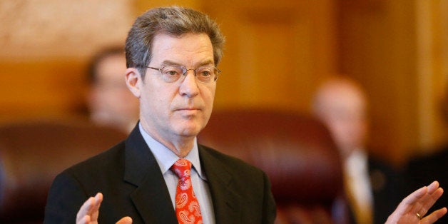 Kansas Gov. Sam Brownback addresses a joint caucus of the state Senate and House Republicans on Thursday, June 11, 2015, stre