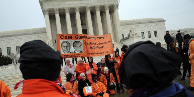 WASHINGTON, DC - JANUARY 11: Members of the organization Witness Against Torture, some of them wearing orange prison jump suits with handcuffs and a hood over their heads, end their demonstration urging the government to close down the detention facility at Guantanamo Bay, outside the U.S. Supreme Court January 11, 2012 in Washington, DC. The group held a 92-hour vigil in protest of the 10th anniversary of the arrival of the first group of detainees to arrive at the US military facility. (Photo by Astrid Riecken/Getty Images)