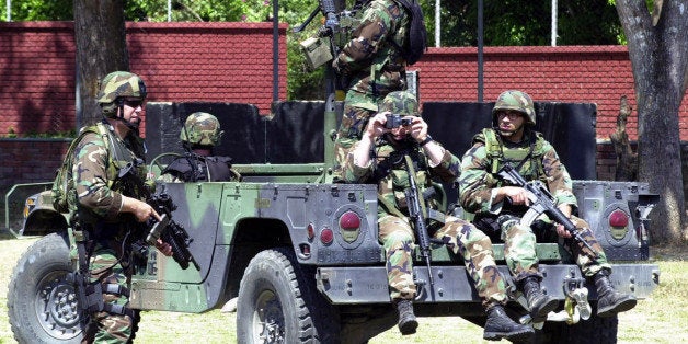 U.S. special forces soldiers stand guard at the 18th Army Brigade headquarters in Arauca, on the northeastern border with Venezuela, during a visit by U.S. ambassador Anne Patterson, Friday, Jan. 17, 2003. U.S. The soldiers are part of a group of Green Berets that arrived in the area to train Colombian army troops to protect a key oil pipeline from attacks by leftist rebels. (AP Photo/Zoe Selsky)