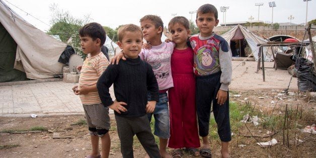 In this photo taken on Friday, Oct. 23, 2015, Children stand at a refugee camp in Latakia, Syria. Latakia, the heartland of Syrian President Bashar Assad's Alawite minority, offers the Russian military a safe environment â and a warm welcome from people blaring car horns and chanting "thanks" in Russian. At a refugee camp in Latakia, which houses several thousand mostly Alawite refugees from other provinces of Syria, smiling kids shouted: "Thank you, Putin!" (AP Photo/Vladimir Isachenkov)