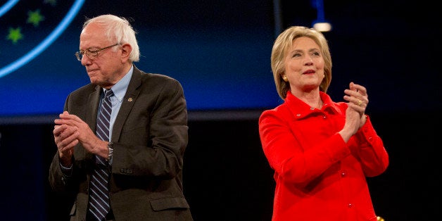 Hillary Clinton, former Secretary of State and 2016 Democratic presidential candidate, right, and Senator Bernie Sanders, an independent from Vermont and 2016 Democratic presidential candidate, applaud and stand on stage together during candidate introductions at the Jefferson-Jackson Dinner in Des Moines, Iowa, U.S., on Saturday, Oct. 24, 2015. With Vice President Joe Biden officially out of the presidential race, the nation's first nominating contest between front-runner Clinton and Sanders is gaining steam, according to a new Bloomberg Politics/Des Moines Register Iowa Poll. Photographer: Daniel Acker/Bloomberg via Getty Images 