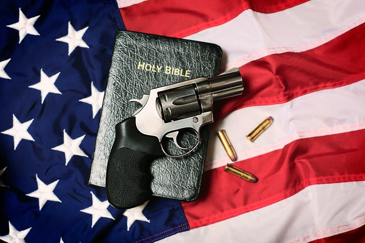 A handgun resting on a Bible and an American flag, representing the Second Amendment of the US Constitution, the right of patriotic Americans to bear arms, and the cross-section of religious American values. Social issues concept.