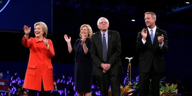 Democratic presidential candidates Hillary Rodham Clinton, left, Sen. Bernie Sanders, I-Vt., second from right, and former Maryland Gov. Martin O'Malley, right, stand on stage together at the start of the Iowa Democratic Party's Jefferson-Jackson Dinner, Saturday, Oct. 24, 2015, in Des Moines, Iowa. Iowa Democratic Party chair Andy McGuire, second from left, looks on. (AP Photo/Charlie Neibergall)