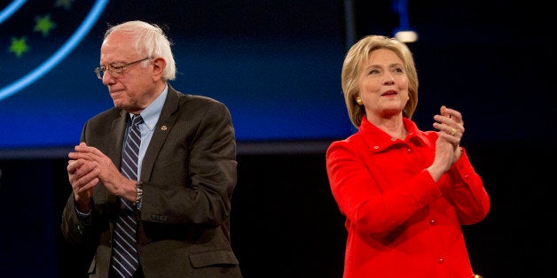 Hillary Clinton, former Secretary of State and 2016 Democratic presidential candidate, right, and Senator Bernie Sanders, an independent from Vermont and 2016 Democratic presidential candidate, applaud and stand on stage together during candidate introductions at the Jefferson-Jackson Dinner in Des Moines, Iowa, U.S., on Saturday, Oct. 24, 2015. With Vice President Joe Biden officially out of the presidential race, the nation's first nominating contest between front-runner Clinton and Sanders is gaining steam, according to a new Bloomberg Politics/Des Moines Register Iowa Poll. Photographer: Daniel Acker/Bloomberg via Getty Images 