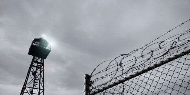 Security tower and razor wire-topped fence