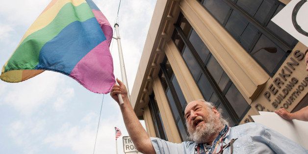 ASHLAND, KY - SEPTEMBER 3: A man waves a gay pride flag during a protest in front of the federal courthouse September 3, 2015 in Ashland, Kentucky. Kim Davis, the Rowan County Clerk of Courts, is expected to appear at a contempt of court hearing at the courthouse today. Citing a sincere religious objection, Davis, who is an Apostolic Christian, has refused to issue marriage licenses to same-sex couples in defiance of a Supreme Court ruling. (Photo by Ty Wright/Getty Images)