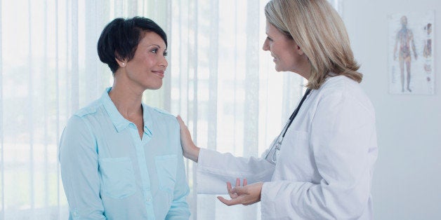 Smiling female doctor talking to patient in office