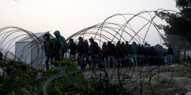 People cross the border from Greece into Macedonia, near the southern Macedonian town of Gevgelija, early Saturday, Nov. 14,