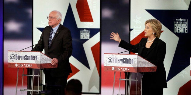 Hillary Rodham Clinton, right, makes a point as Bernie Sanders listens during a Democratic presidential primary debate, Satur