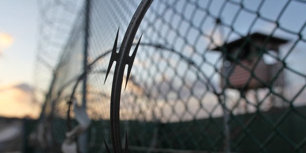 In this photo taken Wednesday, May 13, 2009 and reviewed by the U.S. military, the sun rises over the Guantanamo detention facility at dawn, at the Guantanamo Bay U.S. Naval Base, Cuba. (AP Photo/Brennan Linsley)