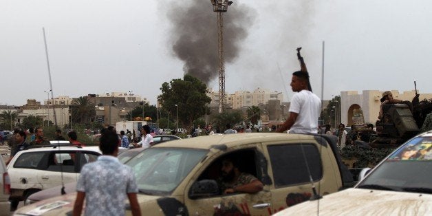 Smoke billows from the site of shelling by anti-governemnt forces as Libyans attended a protest against a national unity gove