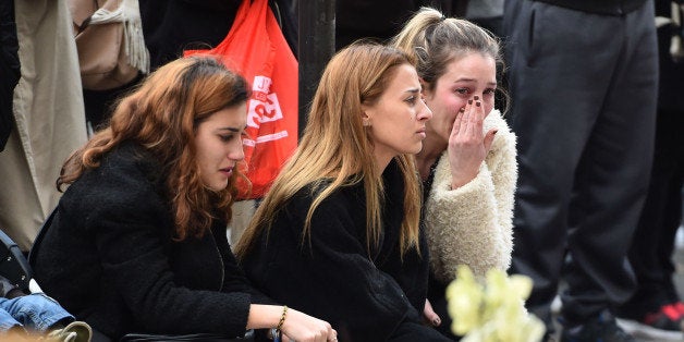 PARIS, FRANCE - NOVEMBER 16: Members of the public stand still at La Belle Equipe cafe on Rue de Charonne, one of the places attacked by terrorists, on November 16, 2015 in Paris, France. Countries across Europe will join France, currently observing three days of national mourning, for a one minute-silence today in an expression of solidarity with the victims of the terrorist attacks, which left at least 129 people dead and hundreds more injured. (Photo by Jeff J Mitchell/Getty Images)