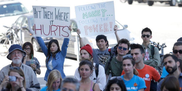 College students and supporters hold up signs at a rally to support fossil fuel divestment outside of City Hall in San Francisco, Thursday, May 2, 2013. In an effort to slow the pace of climate change, students at more than 200 colleges are asking their schools to stop investing in fossil fuel companies. (AP Photo/Jeff Chiu)