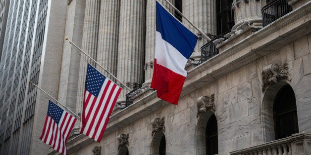 NEW YORK, NY - NOVEMBER 16: French and U.S. flags fly at half mast outside the New York Stock Exchange in honor of the victi