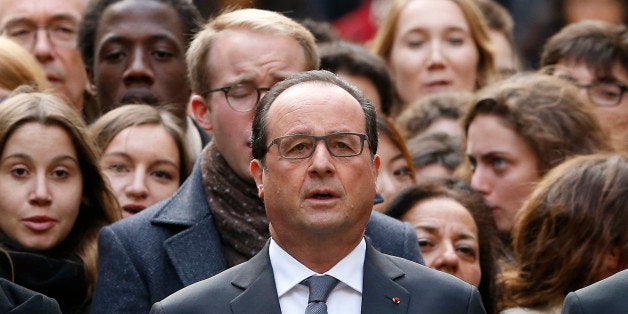 French President Francois Hollande stands among students during a minute of silence in the courtyard of the Sorbonne University in Paris, Monday, Nov. 16 2015. A minute of silence was observed throughout the country in memory of the victims of last Friday's attack. (Guillaume Horcajuelo, Pool via AP)