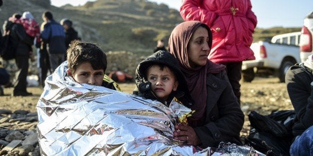 A Syrian family waits after arriving on the Greek island of Lesbos along with other migrants and refugees, on November 17, 20