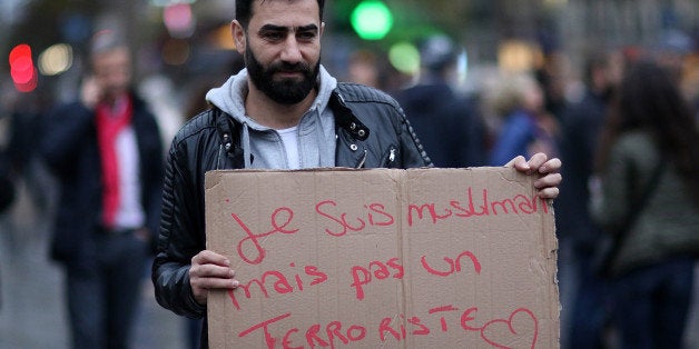 PARIS, FRANCE - NOVEMBER 17: People hold signs at a makeshift memorial at the place de la republique on November 17, 2015 in Paris, France.Paris remains under heightened security following terrorist attacks , which left at least 129 people dead and hundreds more injured. (Photo by Pierre Suu/Getty Images)