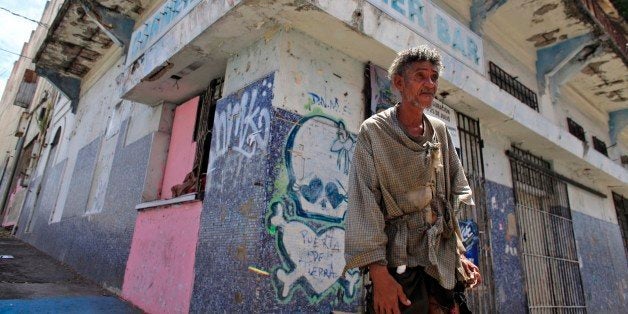 A homeless man stands in front of a closed down business in Puerta de Tierra in the outskirts of Old San Juan, Puerto Rico, S