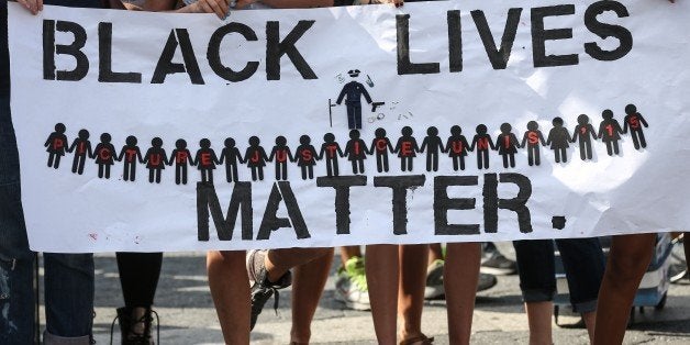 NEW YORK, NY - AUGUST 09: People hold banners reading 'Black Lives Matter' during a rally to mark the one year anniversary of the death of Michael Brown at Union Square in New York, NY on August 09, 2015. Brown was killed by police officer Darren Wilson in Ferguson, Missouri, and his death set off nationwide protest against police brutality. (Photo by Cem Ozdel/Anadolu Agency/Getty Images)