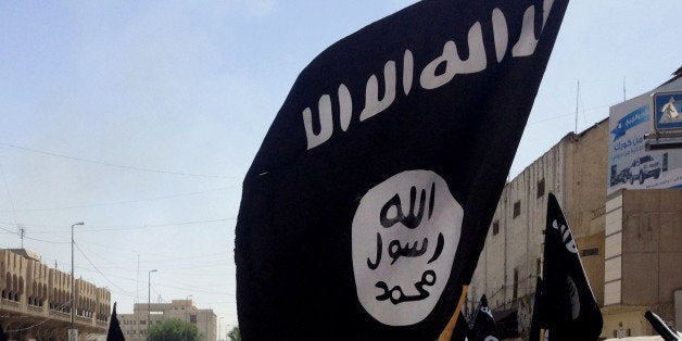 FILE - In this June 16, 2014 file photo, demonstrators chant pro-Islamic State group, slogans as they carry the group's flags