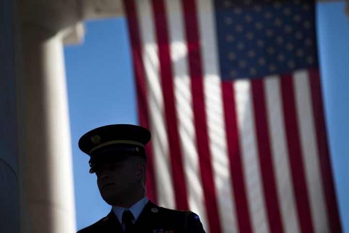 A member of the honor guard waits for the arrival of visitors to the annual Veterans Day Observance Ceremony at Arlington National Cemetery in Arlington, Va., Tuesday, Nov. 11, 2014. Americans marked Veterans Day on Tuesday with parades, speeches and military discounts, while in Europe the holiday known as Armistice Day held special meaning in the centennial year of the start of World War I. (AP Photo/Evan Vucci)