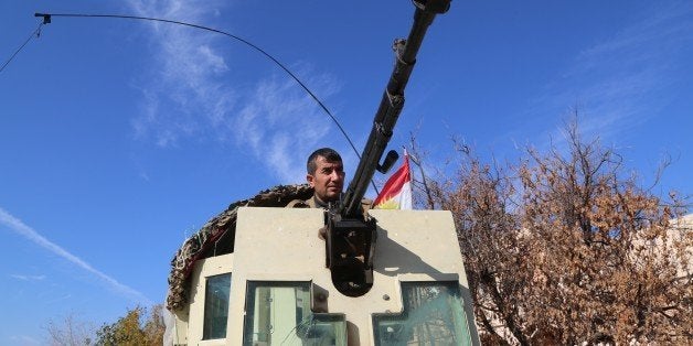 MOSUL, IRAQ - NOVEMBER 20: Peshmerga forces belonging to the Kurdish Regional Government (KRG) in armored vehicle patrol the Sinjar town of Mosul, Iraq on November 20, 2015 after liberating the region from Daesh terrorists. (Photo by Yunus Keles/Anadolu Agency/Getty Images)