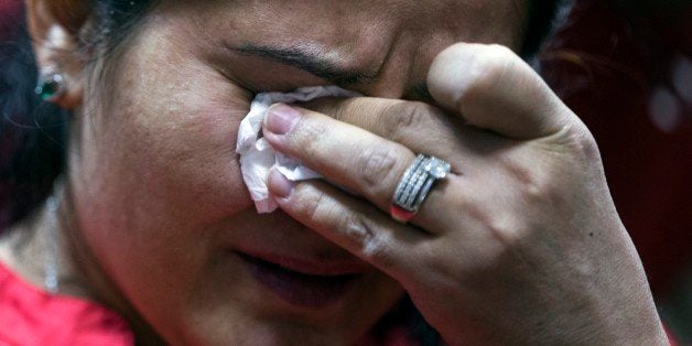 Gulistan, wife of a Syrian migrant, cries before hearings in the Khimki town court outside Moscow, Russia, Thursday, Nov. 19, 2015. A family of migrants from Syria, Hasan Abdo Ahmed, his wife Gulistan and their four children, who have been stranded in the transit area of Moscowâs Sheremetyevo airport for months, faced the Khimki town court outside Moscow on Thursday. The state Federal Migration Service said it could only consider the possibility of granting the family a refugee status following a court ruling on their case. (AP Photo/Pavel Golovkin)