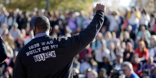 FILE - In this Nov. 9, 2015, file photo, a member of the black student protest group Concerned Student 1950 gestures while addressing a crowd following the announcement that University of Missouri System President Tim Wolfe would resign, at the university in Columbia, Mo. The roots of the protest began decades ago, when the University of Missouri, founded in 1839, enrolled its first black student in 1950. (AP Photo/Jeff Roberson, File)