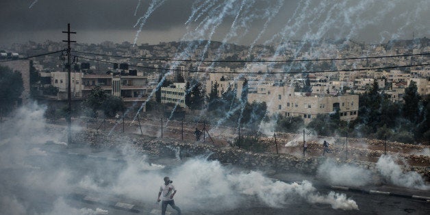 JERUSALEM, Nov. 6, 2015 -- Palestinian protesters evade from a shower of tear gas cylinders shot by Israeli security forces d
